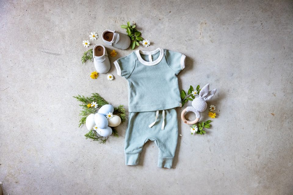 Baby top, trousers and shoes laid flat with small flowers