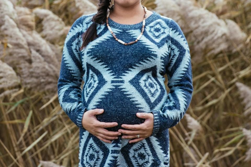 Pregnant woman in a blue patterned knit dress